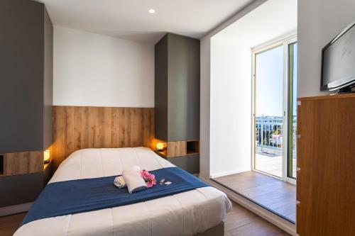 une chambre avec un lit, une télévision et une fenêtre dans l'établissement VUE DES ANGES AP4238 By Riviera Holiday Homes, à Nice