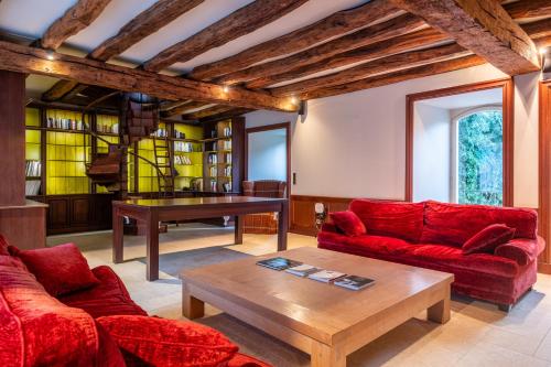 a living room with red couches and a table at Hostellerie de l'Écu de Bretagne in Beaugency