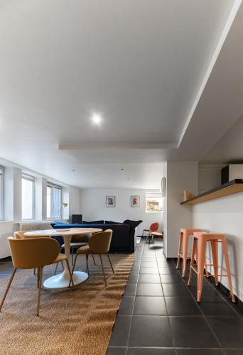un salon avec une table et des chaises dans l'établissement Le Charlot - Appartement design avec parking et terrasse, à Vichy
