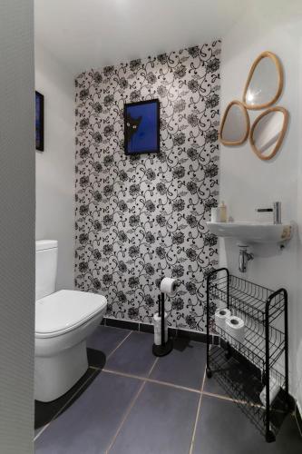 La salle de bains est pourvue de toilettes et d'une télévision murale. dans l'établissement Le Charlot - Appartement design avec parking et terrasse, à Vichy