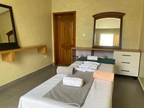 two beds in a room with a mirror at AGASARO LUXURY Apartment in Kigali