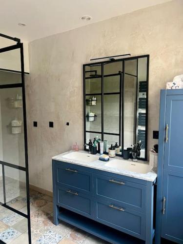 une salle de bain avec un lavabo bleu et un miroir dans l'établissement Maison de campagne avec piscine, à Soisy-Bouy
