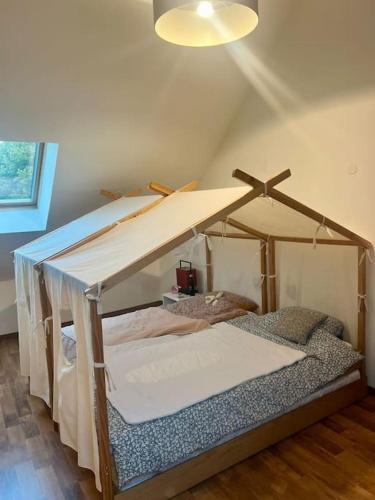 Cette chambre comprend un lit à baldaquin. dans l'établissement Maison de campagne avec piscine, à Soisy-Bouy