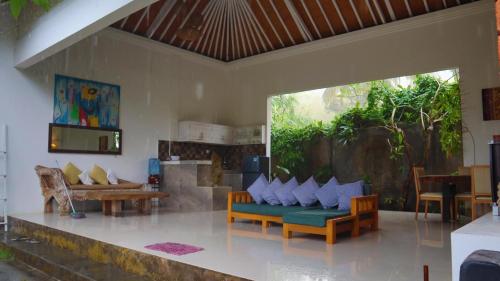a living room with a couch and a table at Pranajaya loka villa in Tejakula