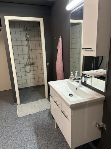a bathroom with a sink and a shower and a mirror at Struer Festcenter - Vest Bowl lejlighed 1 Bredgade 62 C in Struer