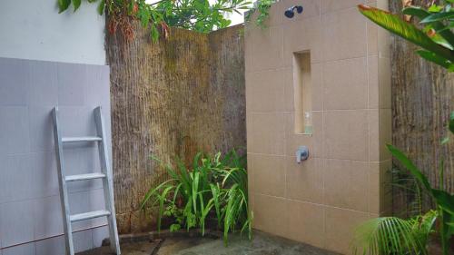 a shower with a ladder next to a wall at Pranajaya loka villa in Tejakula
