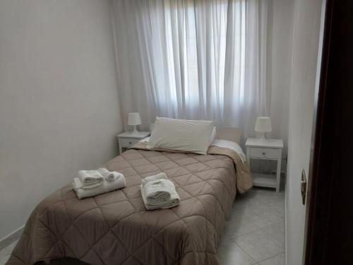 a bedroom with a bed with two towels on it at SUITE - 2 Camere da Letto - Fiumicino Aeroporto e Fiera in Fiumicino
