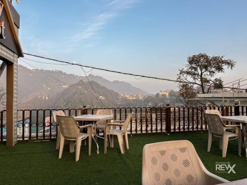 a group of tables and chairs on a balcony at Hotel Sunny Cot - Free Mall Shuttle and Parking in Mussoorie
