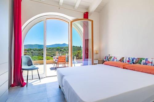 a bedroom with a bed and a large window at Baia di Spartaia 1 in Procchio