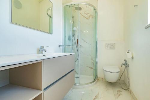 a bathroom with a glass shower and a toilet at Baia di Spartaia 1 in Procchio