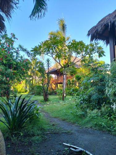 un giardino con una casa sullo sfondo di Tangga Bungalows Gili Air a Gili Air