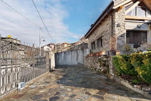 a stone walkway next to a building with a fence at Charmingly Renovated Stone House in Cesara