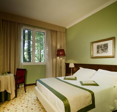 a bedroom with a bed and a table and a window at Meditur Hotel Bologna in Bologna