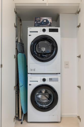 a washer and dryer with a surfboard in a closet at Palazzo Cavour, 34 - Luxury Suite Decumano in Pavia