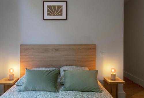 - une chambre avec un lit et 2 lampes sur les tables dans l'établissement Résidence Desroziers - Appartements design en centre ville, à Vichy