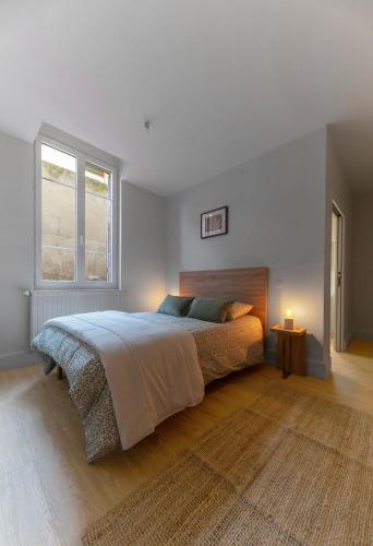 une chambre blanche avec un lit et une fenêtre dans l'établissement Résidence Desroziers - Appartements design en centre ville, à Vichy