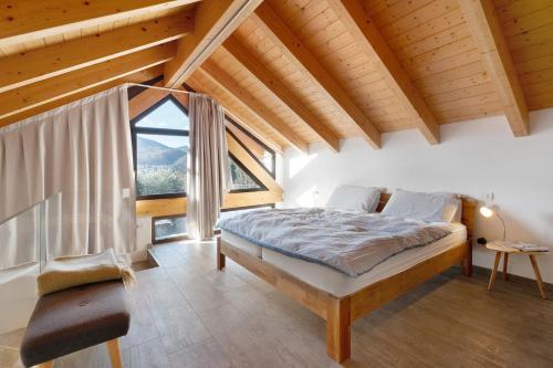 a bedroom with a bed and a large window at Charmingly Renovated Stone House in Cesara
