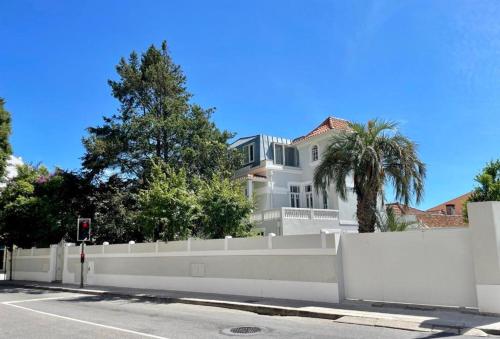 a large white house behind a white fence at Uporto House Palace in Porto