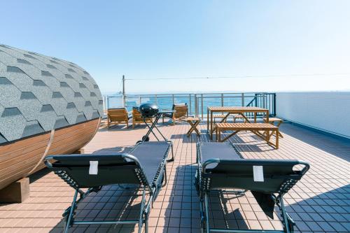 a deck with chairs and tables on a ship at Breeze Awaji Kamaguchi in Awaji