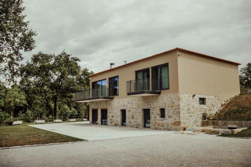 a house with a balcony on top of it at Quinta das Areias - Solar da Pena in Braga