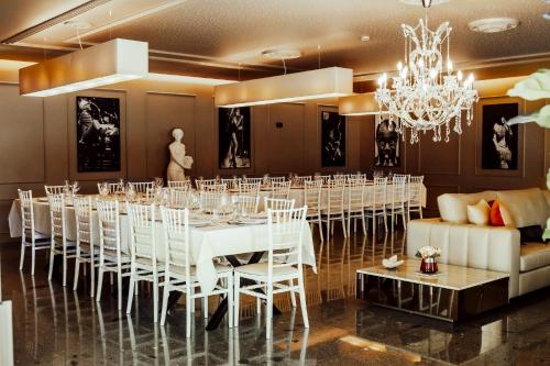 a room with a long table with white chairs and a chandelier at Quinta das Areias - Solar da Pena in Braga