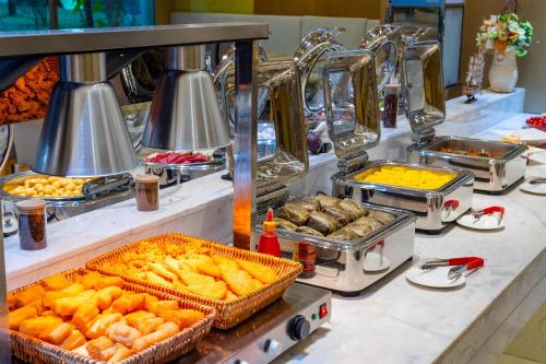 a buffet line with various food items on a counter at Guangzhou Baiyun Airport Rejoice by Argyle Hotel Rehe Metro Exit B --Free shuttle bus is provided during the 138th Canton Fair in Guangzhou