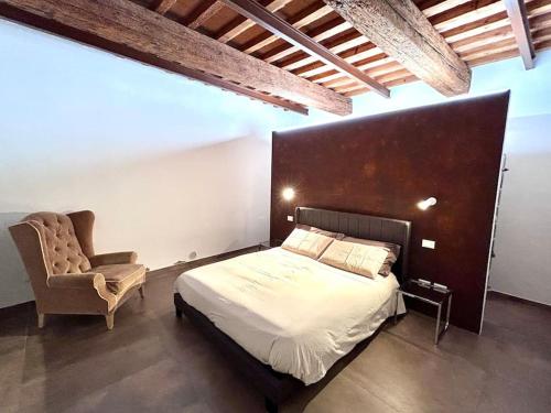 ein Schlafzimmer mit einem Bett und einem Stuhl in der Unterkunft Magda house in Montelupo Fiorentino