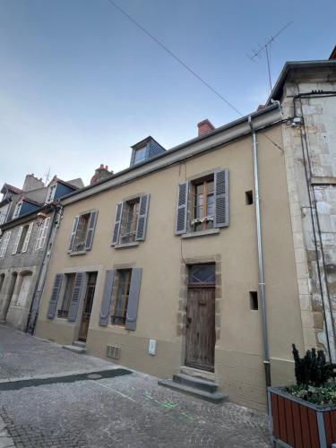 - un bâtiment ancien avec une porte et des fenêtres dans l'établissement Coeur de ville N2, à Montluçon