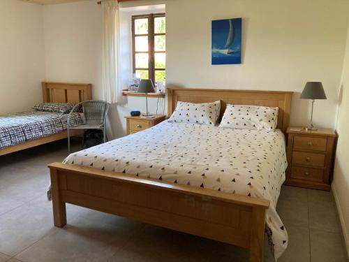 een slaapkamer met een groot bed en een raam bij Mas de la Giralde - Bed and Breakfast in Payzac