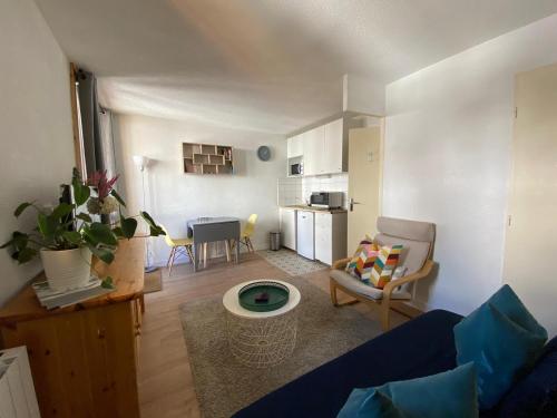 un salon avec un canapé bleu et une cuisine dans l'établissement Andromede, à Les Deux Alpes
