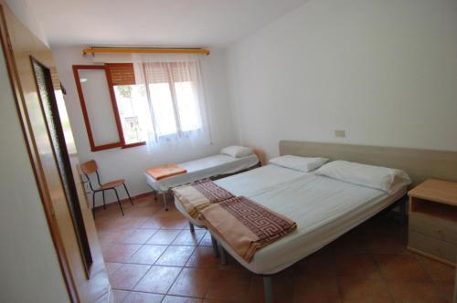 a small bedroom with a bed and a window at Cozy flat in Rosolina in Rosolina Mare