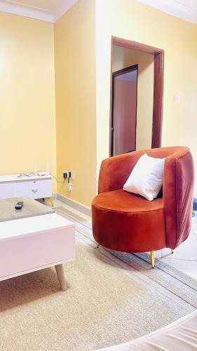 a living room with a brown chair with a white pillow at Spacious City Home in Kampala