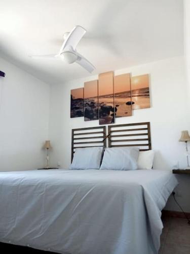 a white bed with two lamps and a ceiling fan at Villa Lanzarote Zen in Playa Blanca
