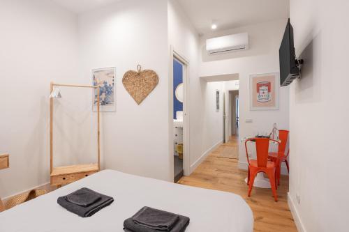 a bedroom with a bed and a table and a chair at The Idyll Boutique apartment - Suite in Napoli's Spanish Quarters in Naples