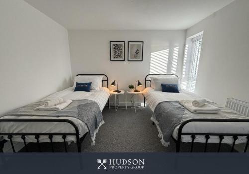 Dos camas individuales en una habitación con ventana. en Shrewsbury Townhouse with 3 En-suites, en Shrewsbury