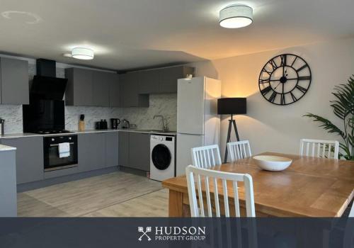 a kitchen with a table and a clock on the wall at Shrewsbury Townhouse with 3 En-suites in Shrewsbury