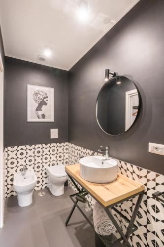 a bathroom with a sink and a toilet at The Idyll Boutique apartment - Suite in Napoli's Spanish Quarters in Naples