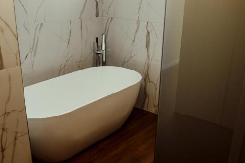 a white bath tub in a bathroom with marble walls at Quinta das Areias - Solar da Pena in Braga
