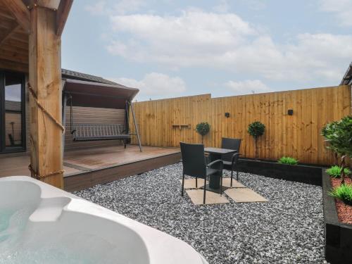a backyard with a bath tub and a wooden fence at Spindle in Swadlincote
