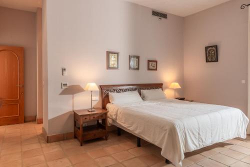 a bedroom with a bed and two lamps on tables at Villa Iris in Benalup Casas Viejas
