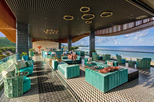 a hotel lobby with chairs and tables and the ocean at Angsana Quan Lan, Ha Long Bay in Quan Lạn
