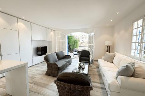 un salon avec un canapé blanc et des chaises dans l'établissement Charming House for Rent in Port Grimaud with Wi-Fi and Private Mooring, à Grimaud