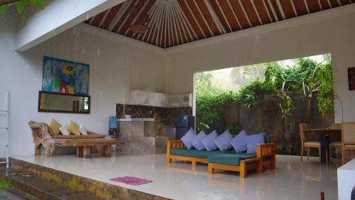 a living room with a couch and a table at Pranajaya loka villa in Tejakula