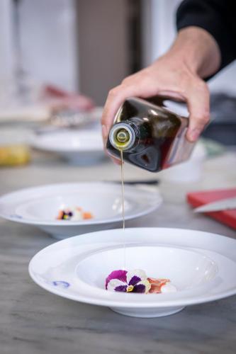 a person pouring food onto a plate on a table at Hotel Parrini in Follonica