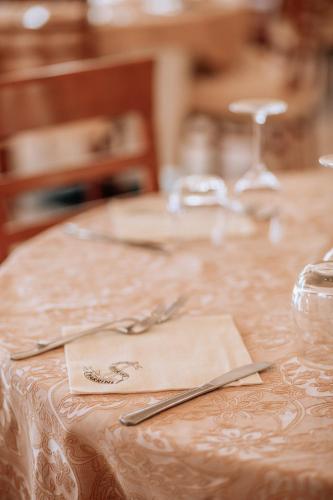 a table with a table cloth with a fork and knife at Hotel Parrini in Follonica