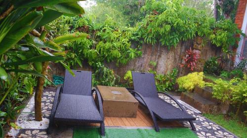 two blue chairs and a table in a garden at Pranajaya loka villa in Tejakula