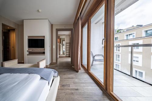 a bedroom with a bed and a large window at Hotel Piz St. Moritz in St. Moritz