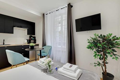 a room with a bed and a table with towels at Cozy studio -2P- Sorbonne Institute- Latin quarter in Paris