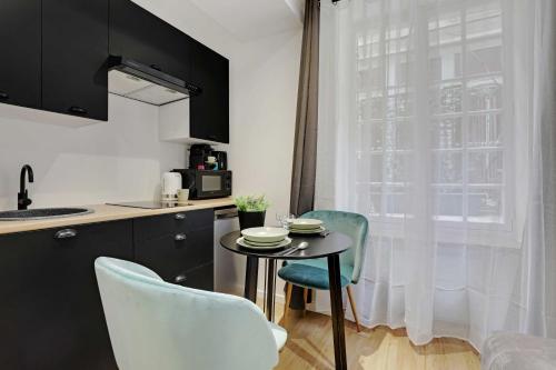 a small kitchen with a table and chairs and a window at Cozy studio -2P- Sorbonne Institute- Latin quarter in Paris