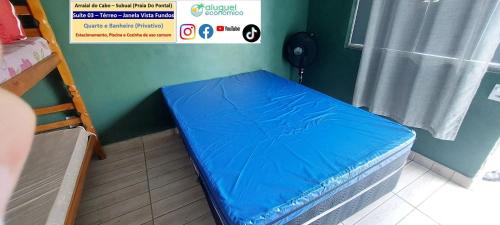a small bed in a room with a green wall at Arraial do Cabo – Subuai Village - Aluguel Econômico in Arraial do Cabo